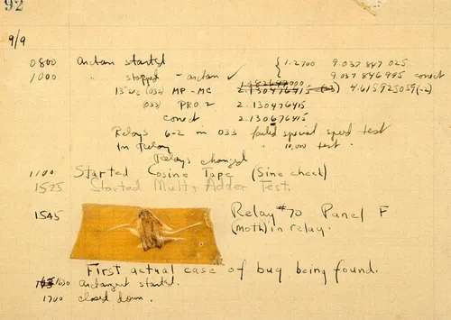 A log book. Written primarily in black ink. An insect’s body is on the page. There is tape overtop the insect’s body to preserve the world’s “first computer bug”.