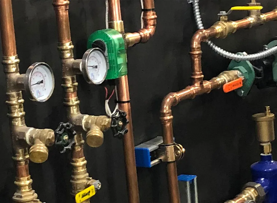 Wall with a network of copper pipes and valves
